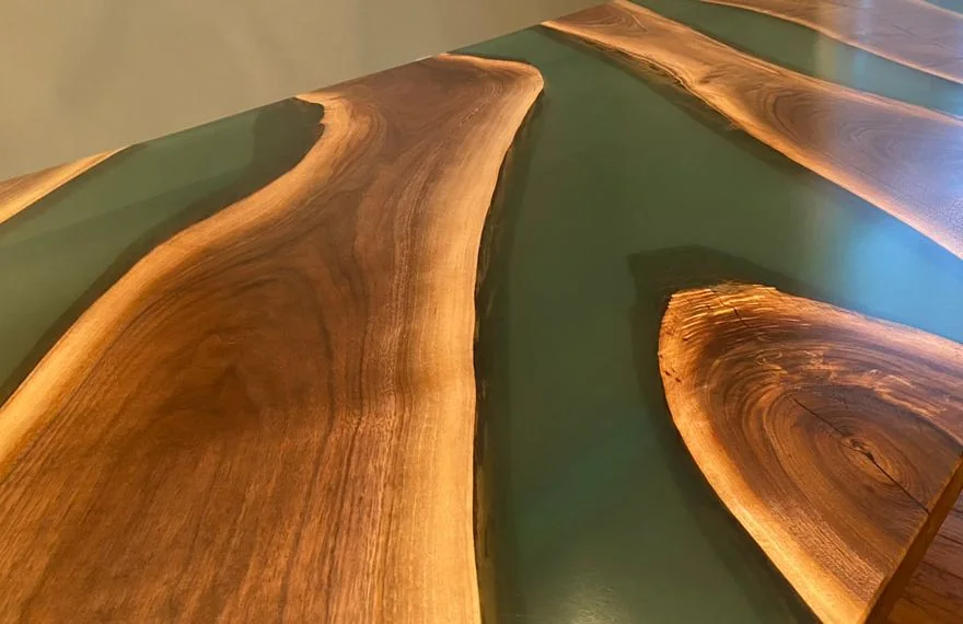 Wood table with green resin inlays and natural grain patterns.