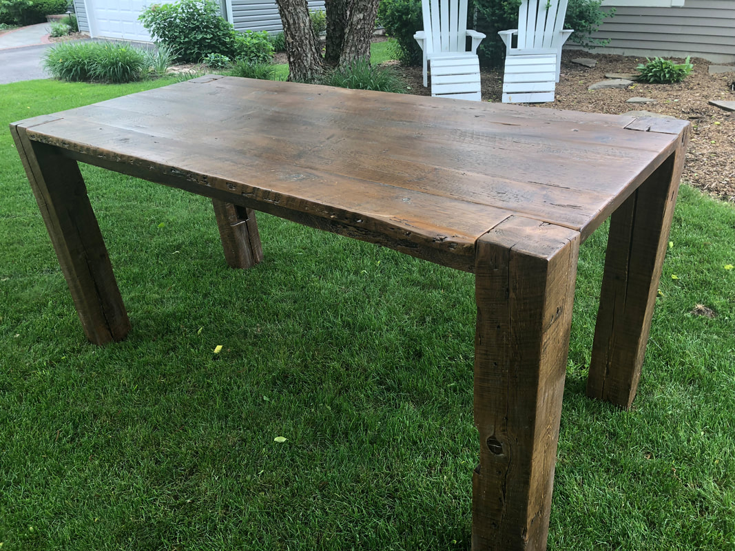 Rustic barnwood table with thick barnwood beam legs finished with a satin sealer